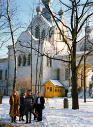Värvifoto viiest koguduse liikmest Püha Aleksandri kiriku aia ees Sõbra tänaval lumisel päeval